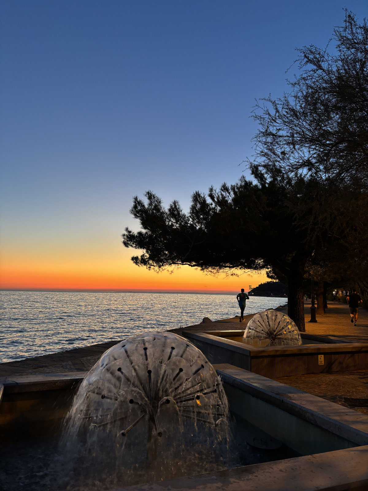 Sunset over the Adriatic Sea along the Trieste waterfront promenade