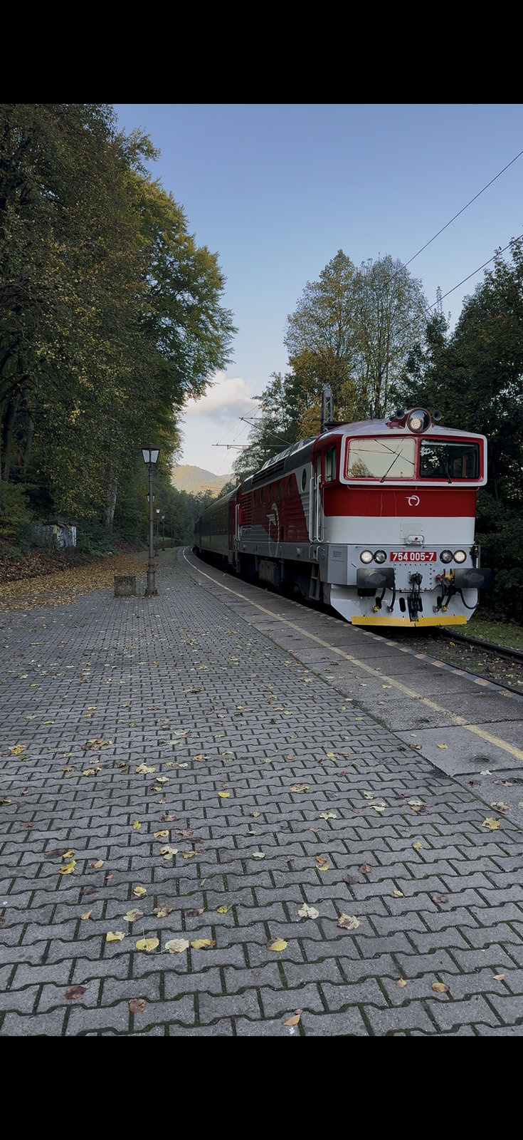 Red ZSSK locomotive at a scenic Central European station in autumn